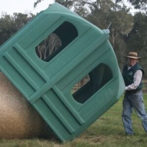 Man holding up a Hayhut against a bale of hay